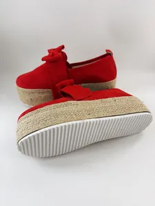Detailed macro view of red suede platform loafers with bow and espadrille wedge sole