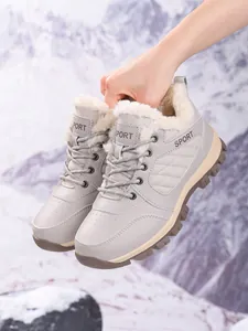 Detail view of grey women's snow boots with warm faux fur lining and thick soles.