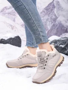 Waterproof women's high-top winter snow boots with thick plush lining in snow scene