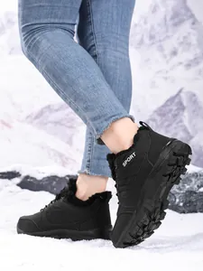 Close-up of black waterproof high-top snow boots with warm fur lining shown on snow