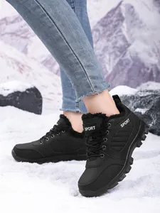 Women's black fur-lined waterproof snow boots shown in a snowy mountain setting