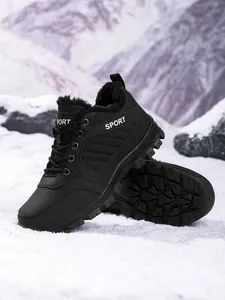 Detailed view of black waterproof women's snow boots with warm fur lining on a snowy landscape