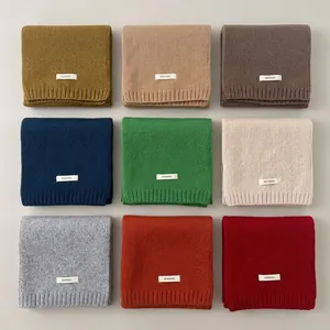 A detailed macro view of nine multi-colored knitted mohair-style scarves in a grid