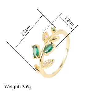 Detail view of a leaf-shaped gold ring with marquise green gems and dimensions