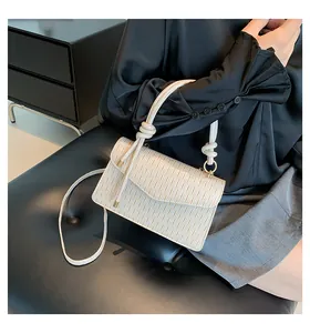 Dettaglio della piccola borsa quadrata plissettata color crema con manico a nodo moda