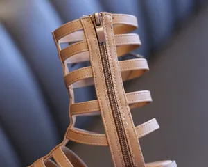 Close-up macro view of the smooth zipper and stitching on children's gladiator sandals.