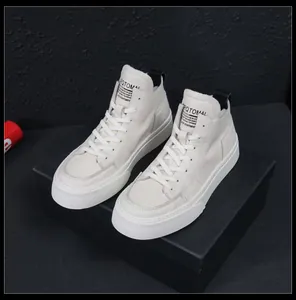 Vista dettagliata di sneaker alte in pelle bianco sporco con suole spesse ed etichetta