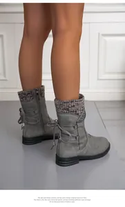 Close-up detail of stylish grey women's winter boots with knitted cuffs and back lacing