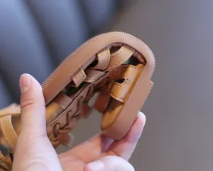 Close-up of flexible brown girl's Roman sandals showing extremely soft sole for child comfort