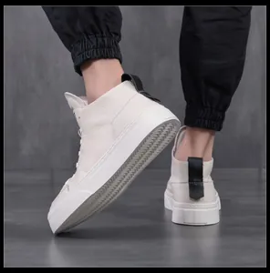 Primo piano di sneaker alte in pelle bianca con suole spesse e linguetta nera sul tallone.