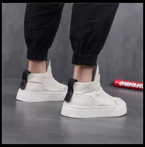 Primo piano di sneakers alte da uomo in pelle bianca con suole spesse e linguetta nera