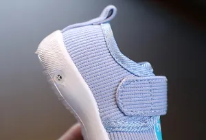 Gros plan de chaussure de marche bébé en tricot violet avec fermeture velcro