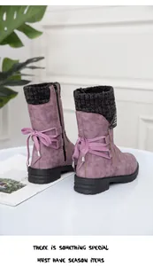 Back view of purple winter boots with black knit collar and decorative bow details