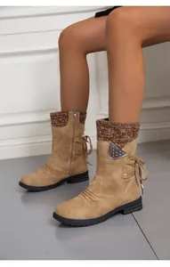 Close-up view of tan mid-calf boots with knitted cuffs and stylish ribbon bow design