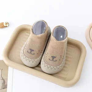 Gedetailleerde weergave van schattige baby sok-schoenen met beer en antislip rubberen zolen