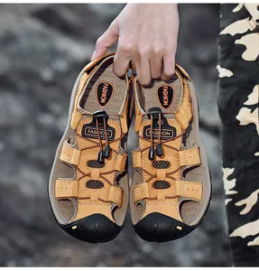 Handheld close-up showing the textured leather and closed-toe design of men's sandals