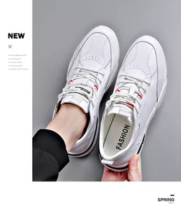 Top-down detail view of stylish white leather casual sneakers for men on gray background