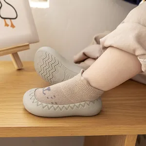 Detailopname van beige gebreide babyslofjes met antislip grijze rubberen zool