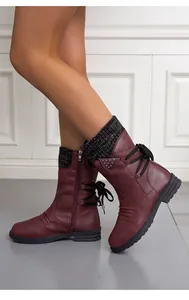 Detailed view of burgundy mid-calf boots with knitted collar and lace-up back worn by model