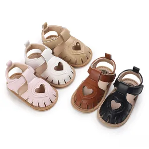 Gros plan de sandales pour bébé fille avec motif cœur en plusieurs couleurs d'été