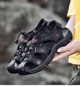 Detail of men's black closed-toe outdoor leather sandals with red stitching and logo
