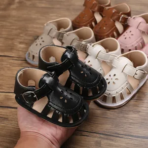 Nahaufnahme von Baby-Lauflern-Sandalen mit Blumenausschnitten und Schnallenriemen.