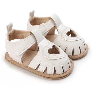 Détail de sandales blanches pour bébé avec découpe en cœur et semelle souple respirante