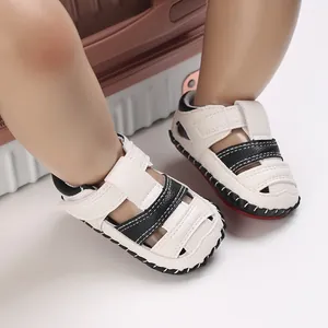 Gros plan de sandales en cuir blanc pour bébé avec lanières noires et semelles en gomme