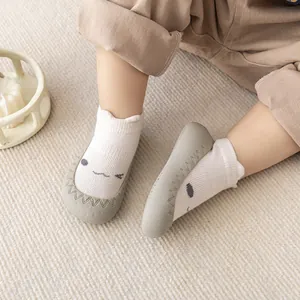Detailweergave van antislip babysok-schoenen met cartoongezicht en rubberen zool