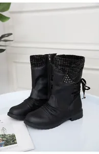 Side detail of black flat boots showing the knit cuff and back ribbon decorative studs.