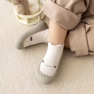 Detail van antislip babysokschoenen met cartoongezicht op een peuter gedragen.