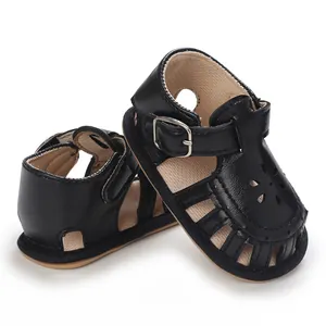 Nahaufnahme schwarzer Baby-Lauflern-Sandalen aus Leder mit floralem Ausschnitt-Design
