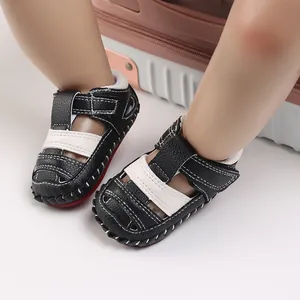 Vue détaillée des sandales pour bébé noires et blanches avec semelle en caoutchouc antidérapante