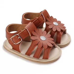 Detailansicht von braunen Baby-Prinzessin-Sandalen mit eleganter glitzernder Blumenverzierung