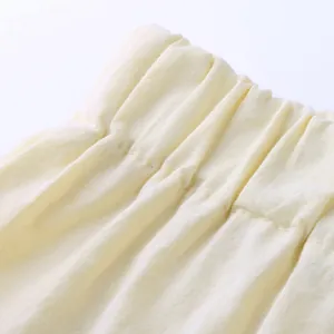 Detail shot of the comfortable elastic waistband on men's cream cotton linen shorts