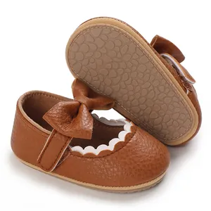 Close-up detail of brown baby girl princess walking shoes with soft non-slip sole and bow