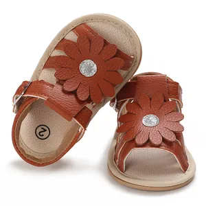 Nahaufnahme von braunen Baby-Prinzessin-Sandalen mit großer Blume und silberner Mitte.