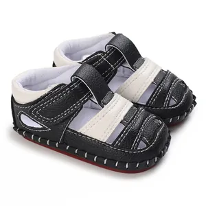 Vue rapprochée de sandales d'été pour bébé en cuir noir avec coutures blanches contrastées