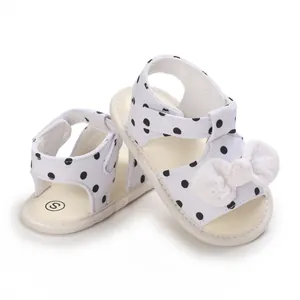 Nahaufnahme von Baby-Polka-Dot-Sandalen mit einer feinen weißen Spitze-Schleife