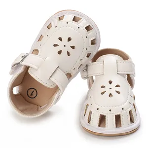 Detailansicht weißer Baby-Sandalen mit Blumenausschnitten und einer weichen Sohle.