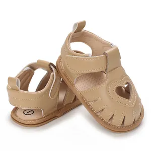 Détail de sandales beiges pour bébé fille avec découpe en cœur et semelle souple