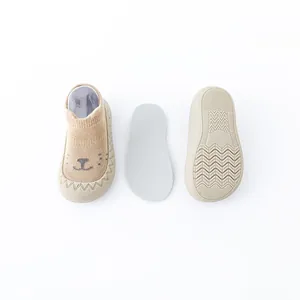 Gedetailleerde weergave van baby-sok-schoenen met beertje en antislip rubberen zool