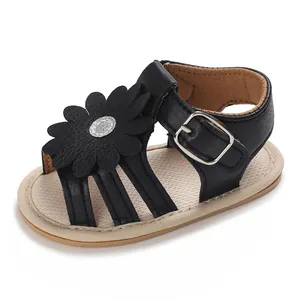 Detailansicht der schwarzen Baby-Sandalen mit dekorativer Blume und verstellbarer Schnalle.