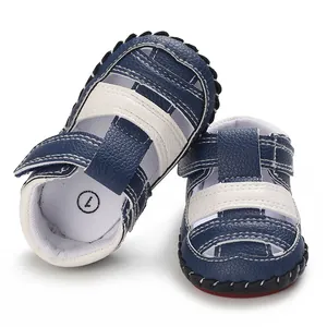 Vue détaillée de sandales pour bébé en cuir bleu marine et blanc avec semelles souples
