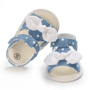 Detailansicht der blauen Polka-Dot-Babysandalen mit weicher Sohle und weißer Schleife.