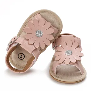 Nahaufnahme von rosa Babysandalen mit großer Lederblume und Glitzerzentrum-Detail