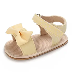 Soft-soled yellow summer baby girl sandals featuring decorative bow and polka dot straps