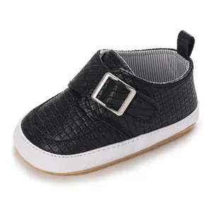 Gros plan d'une chaussure de marche pour bébé noire texturée avec semelle blanche souple