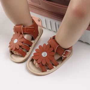 Nahaufnahme von braunen Baby-Prinzessinnen-Sandalen mit großer Blume und Gummisohle.