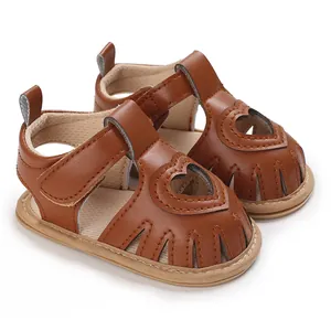 Vue détaillée de sandales marron pour bébé fille avec motif cœur ajouré et semelles souples